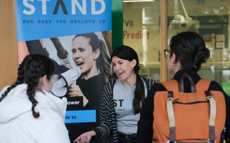 A member of staff from STAND speak to two UCD students at the UCD Volunteer Day Fair